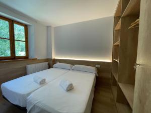 twee bedden in een kamer met twee handdoeken erop bij Apartamentos La Solana in Pla de l'Ermita