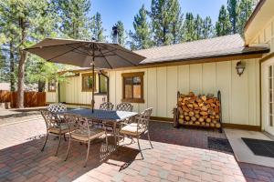 a patio with a table and chairs and an umbrella at Central Big Bear Lake Retreat with Private Hot Tub! in Big Bear Lake