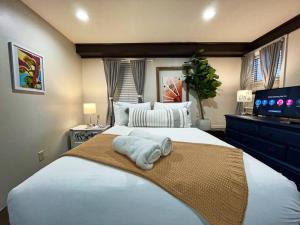 Schlafzimmer mit einem großen weißen Bett und einem Flachbild-TV in der Unterkunft Artist's apartment in the heart of the city in Sacramento
