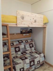 een kleine slaapkamer met een stapelbed en een sprei bij Superdévoluy Les Issarts in Superdevoluy