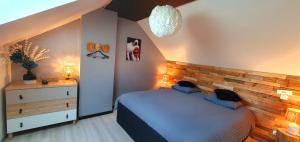 een slaapkamer met een bed en een dressoir bij Espace détente Champagney in Champagney
