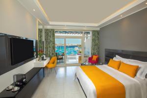 een slaapkamer met een groot bed en een televisie bij Naama Bay Suites & SPA in Sharm El Sheikh