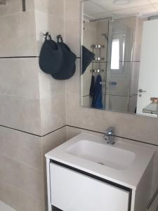 a bathroom with a white sink and a mirror at 3018 Vistabella- Malibu in Orihuela