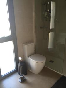 a bathroom with a white toilet and a shower at 3018 Vistabella- Malibu in Orihuela