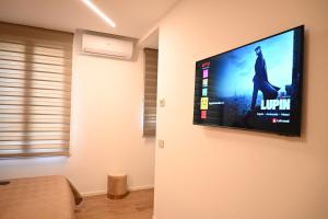 a living room with a flat screen tv on a wall at Garofoli Apartments in San Giovanni Lupatoto