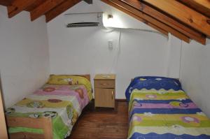 a room with two beds and a night stand in it at Perick Termas in Colón