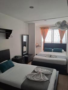 1 Schlafzimmer mit 2 Betten und einem großen Fenster in der Unterkunft Hotel Bolivariano in Ibagué