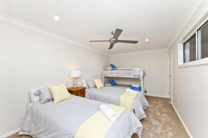 2 łóżka w pokoju z wentylatorem sufitowym w obiekcie Beachside Haven - Your Perfect Oasis Home w mieście Nelson Bay