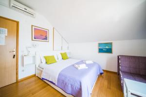 Rooms Denoble客房内的一张或多张床位