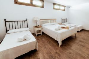 a room with three beds with white sheets at Private Villa Martaver, swiming pool, BBQ & Pool table in Muchamiel