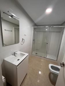 uma casa de banho com um chuveiro, um lavatório e um WC. em Mars Suites Alondra em Madri