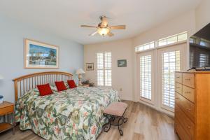 1 dormitorio con 1 cama y ventilador de techo en Seaside at Anastasia F305, en St. Augustine