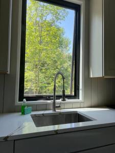un lavandino con finestra in cucina di The Hill Top Hall at Camp Bluestone. a Thompson