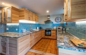 una cucina con armadi in legno e piastrelle blu di Lovely Home In Argentonnay With Wifi a Saint-Clémentin