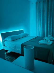 een slaapkamer met een bed met een blauw licht bij SHUBY HOME in San Pietro Vernotico