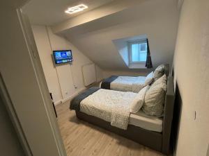 een kleine slaapkamer met 2 bedden en een televisie bij Apartment Delux mit 4 Schlafzimmer in Rastatt