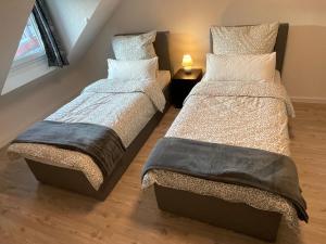 two beds sitting next to each other in a bedroom at Ferienwohnung Rastatt in Rastatt