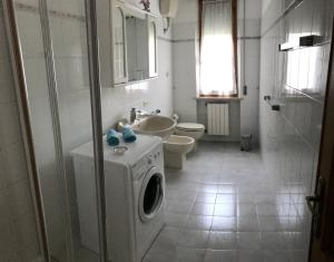 ein Badezimmer mit einer Waschmaschine und einem Waschbecken in der Unterkunft Casa Dani con piscina privata in Monticiano