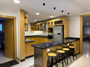 a kitchen with wooden cabinets and a counter with stools at Queen plaza Nasr City in Cairo