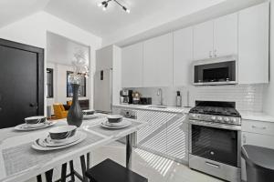 布魯克林的住宿－Cozy 3BR Brooklyn Artisan Loft，厨房配有桌子和炉灶。 顶部烤箱