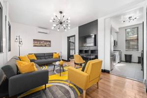 a living room with a couch and yellow chairs at Cozy 3BR Brooklyn Artisan Loft in Brooklyn