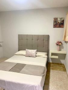 Un dormitorio con una cama grande con una almohada. en Hotel Bahia Suite, en Santa Marta