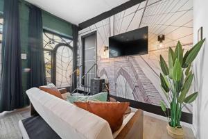 - un salon avec un canapé et une télévision murale dans l'établissement Artistic Cozy Loft Retreat, à Brooklyn