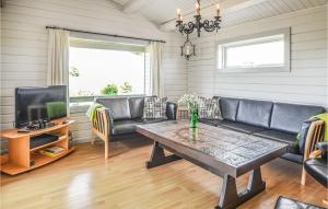 a living room with a couch and a table at Awesome Home In Ebeltoft With 3 Bedrooms, Sauna And Wifi in Ebeltoft