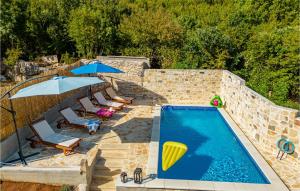 una vista aérea de una piscina con sillas y sombrillas en 3 Bedroom Lovely Home In Bruska, en Donja Bruška
