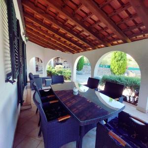 un patio al aire libre con mesa y sillas en Charming Villa Nika with the pool, en Supetar
