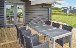 een terras met een tafel en stoelen bij 4 Bedroom Awesome Home In Hadsund in Haslevgårde