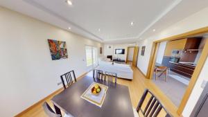 a dining room and living room with a table and chairs at Zion guest house in Almada