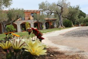 a garden with flowers in front of a building at Park Hotel Cilento in Marina di Camerota