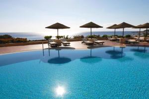 una gran piscina con sillas y sombrillas en GRACE HOUSE DOMINA CORAL BAY, en Sharm El Sheikh