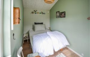 Cette petite chambre comprend un lit avec des draps blancs. dans l'établissement Nice Home In Anholt With Wifi, à Anholt