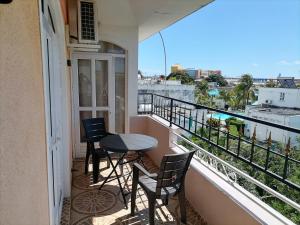 a balcony with a table and chairs and a view at Roshnee Apartments and Studios in Grand-Baie