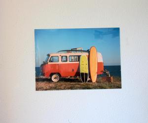 an old red van with two surfboards next to it at Entre Playa y Puntal in Somo