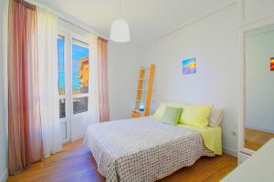 a bedroom with a bed and a window at Entre Playa y Puntal in Somo