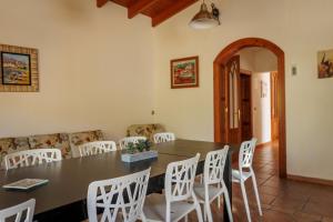 una sala da pranzo con tavolo e sedie bianche di Finca Malagueando a Málaga