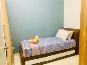 una cama pequeña con un animal de peluche sentado en ella en UMAR HOMESTAY - Alanis KLIA, en Sepang