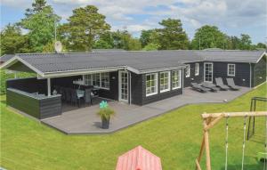 una pequeña casa con terraza en un patio en 5 Bedroom Awesome Home In Hadsund en Nørre Hurup