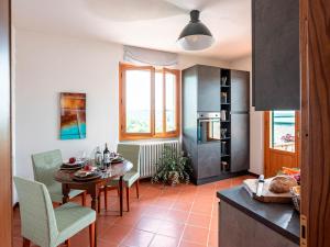 cocina y comedor con mesa y sillas en Olearum apartment (free Parking), en Pieve di Panzano