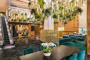 a lobby with tables and chairs and chandeliers at The Delphi Hotel in Los Angeles