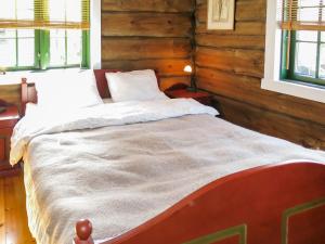 uma cama num quarto com paredes e janelas de madeira em Chalet Josteinbu by Interhome em Kyrkjebygdi