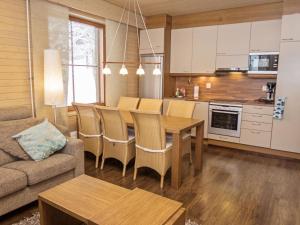 eine Küche und ein Wohnzimmer mit einem Tisch und einer Couch in der Unterkunft Holiday Home Länsirinne e 19 by Interhome in Ruka