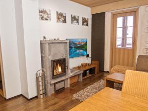 ein Wohnzimmer mit Kamin und Fernseher in der Unterkunft Holiday Home Länsirinne e 19 by Interhome in Ruka