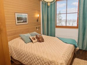 ein Schlafzimmer mit einem Bett, auf dem ein Teddybär liegt in der Unterkunft Holiday Home Länsirinne e 19 by Interhome in Ruka