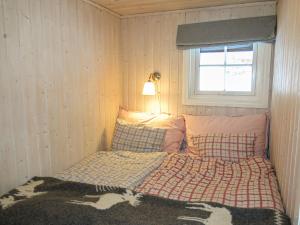 a small bedroom with a bed with a window at Chalet Fjellkos - SOW146 by Interhome in Fossdal