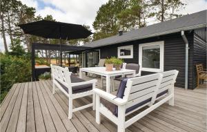 エーベルトフトにあるAwesome Home In Ebeltoft With 3 Bedrooms And Wifiのデッキ(テーブル、椅子、パラソル付)