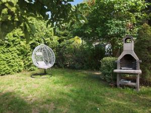 a metal fan sitting in the grass next to a bird house at Holiday Home Parkowa by Interhome in Koszalin